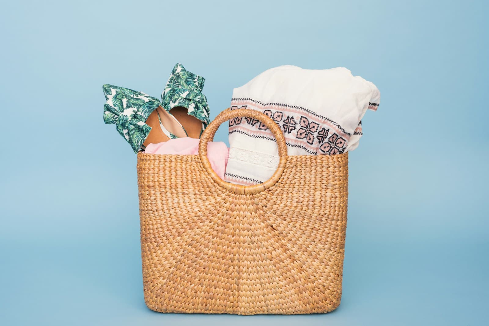 Baby shower gift basket with baby clothes on a pastel blue background