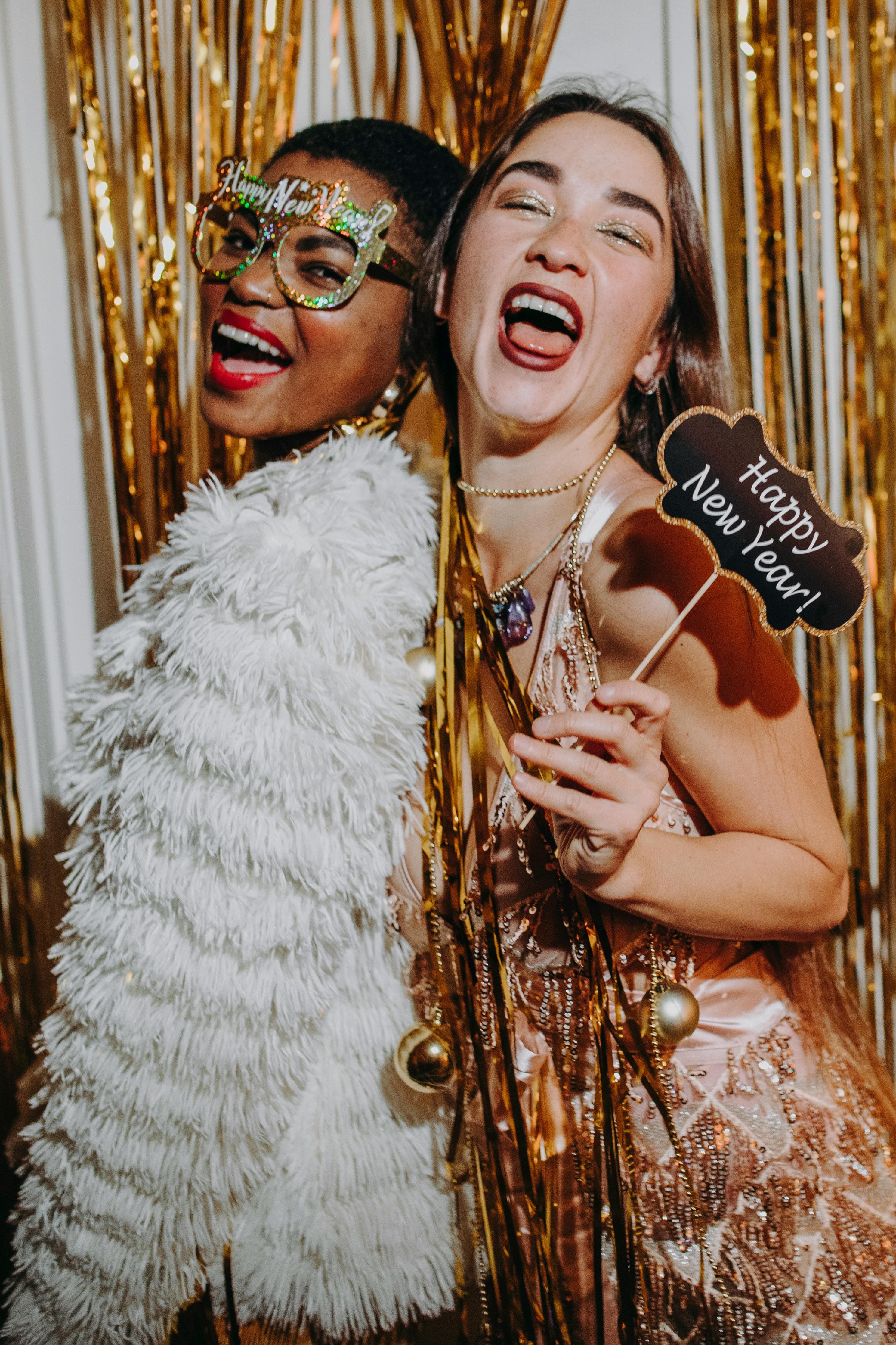 Wedding guests having fun at a photo booth with props and a floral backdrop