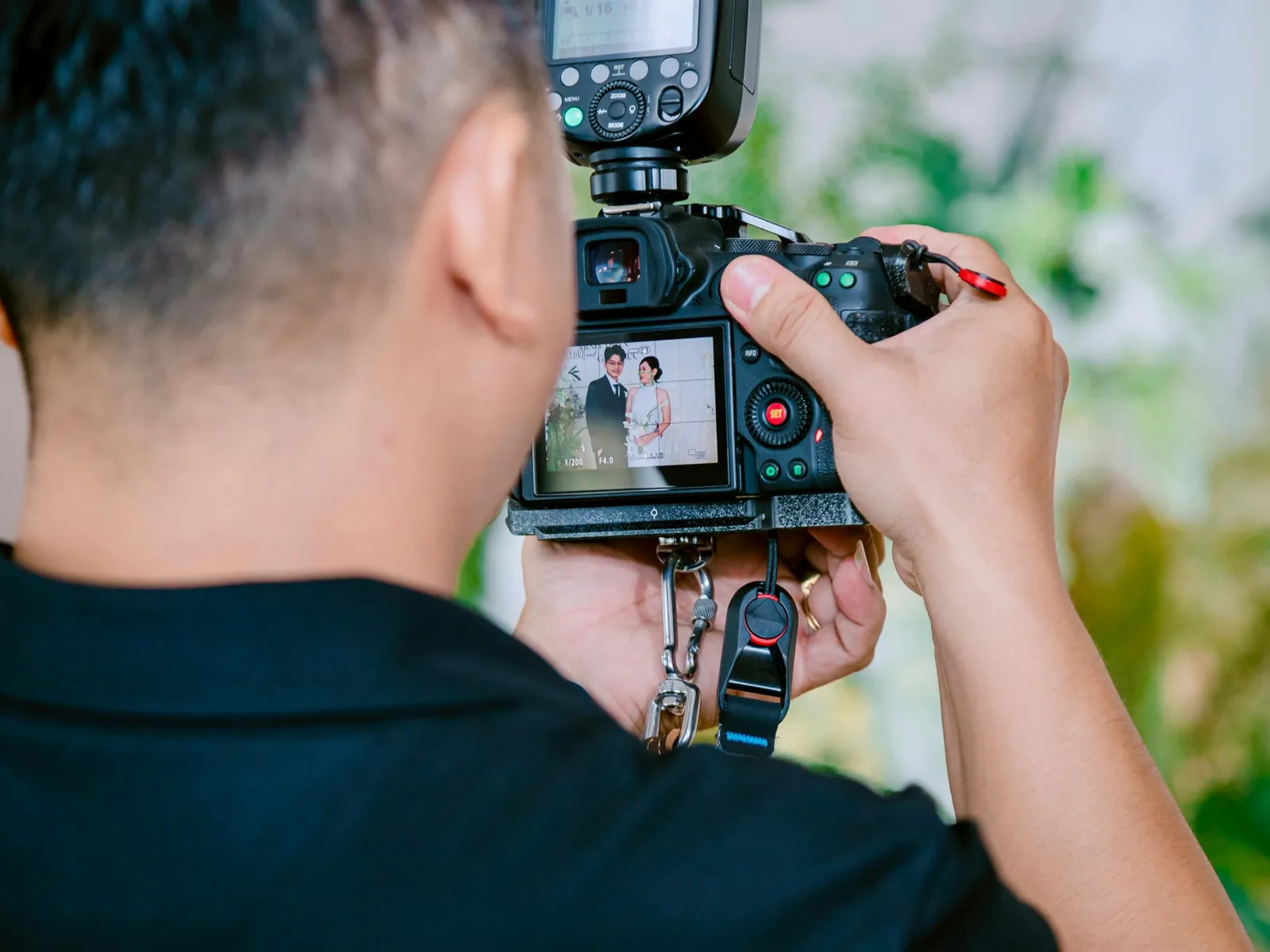 A photographer checking a shot on the camera at a wedding