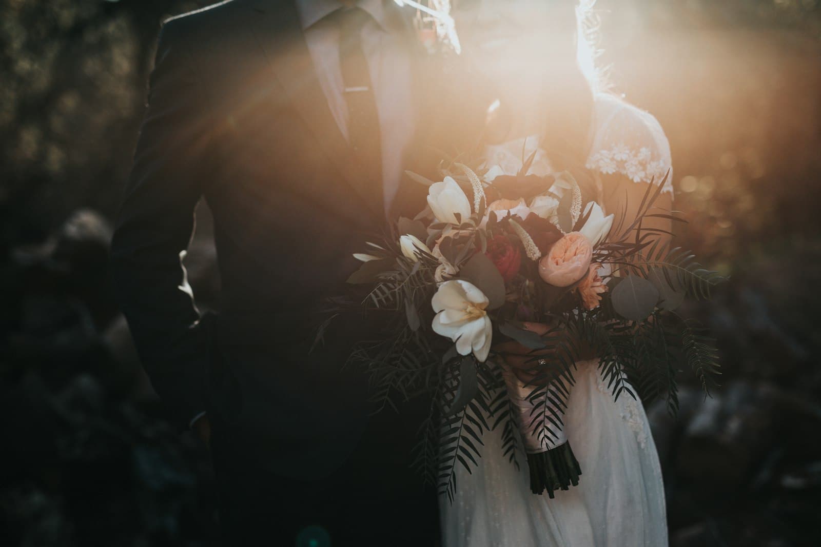 Bride and groom with a bouquet in golden evening light