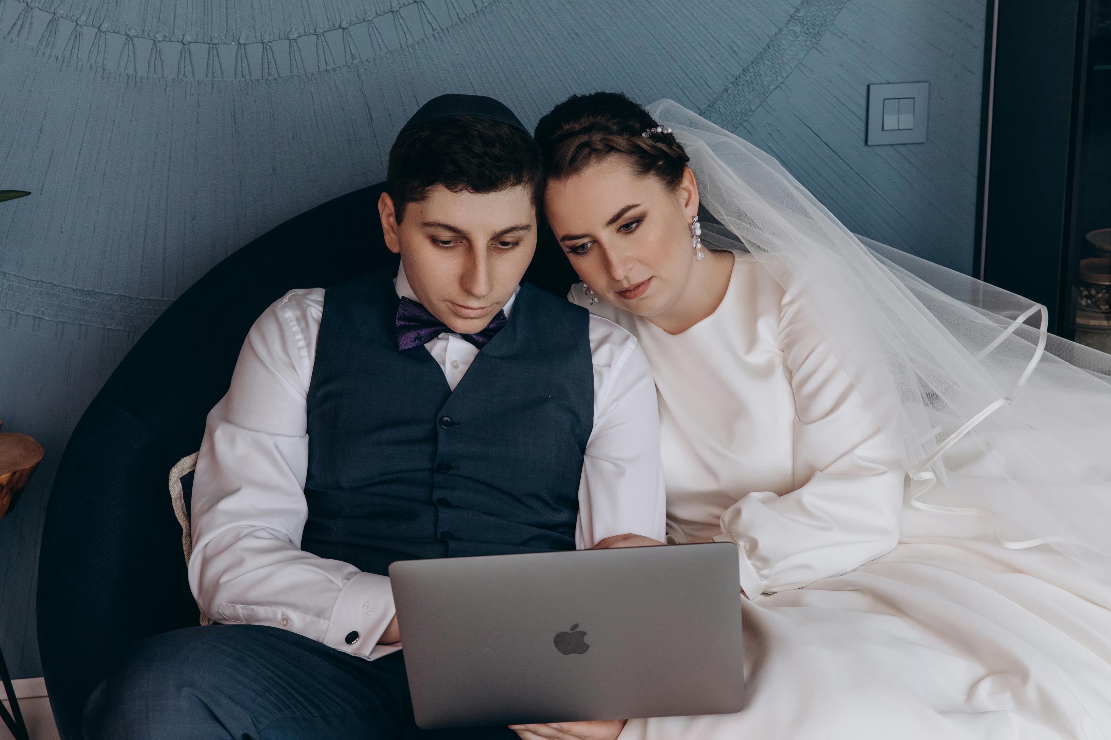 Couple sharing wedding photos on a laptop with family members