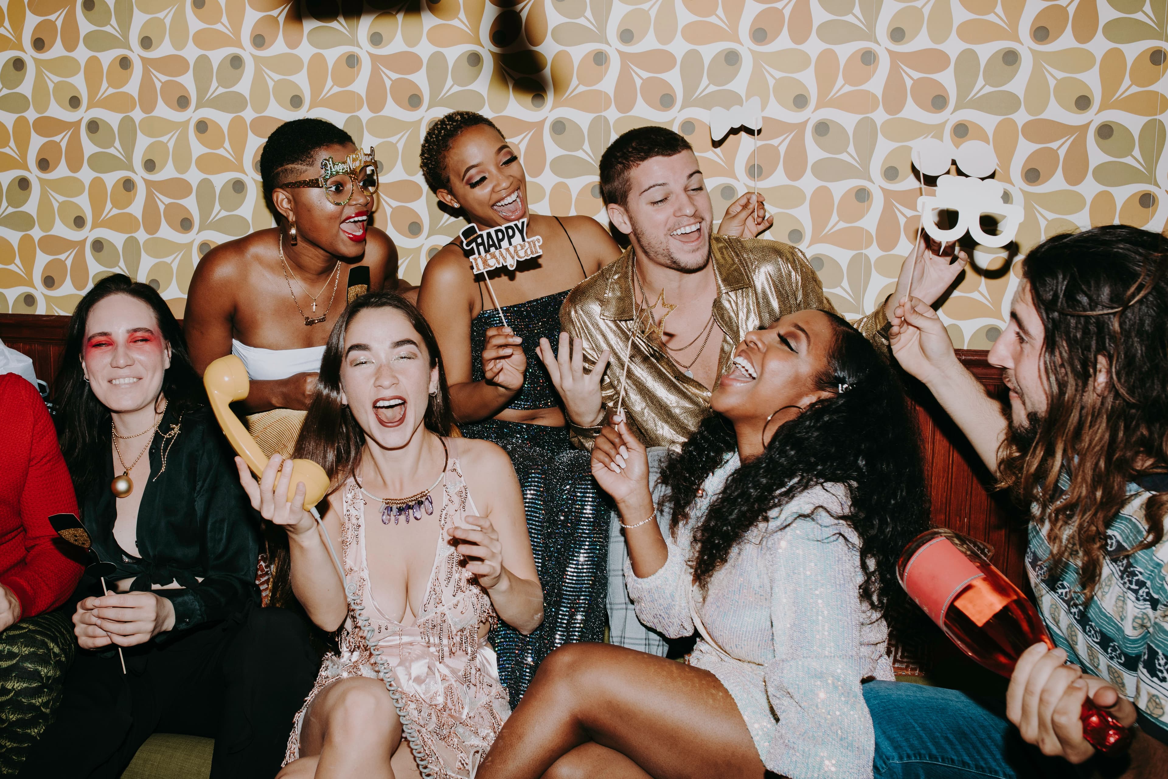 Hen party group celebrating with photo booth props and DIY backdrop